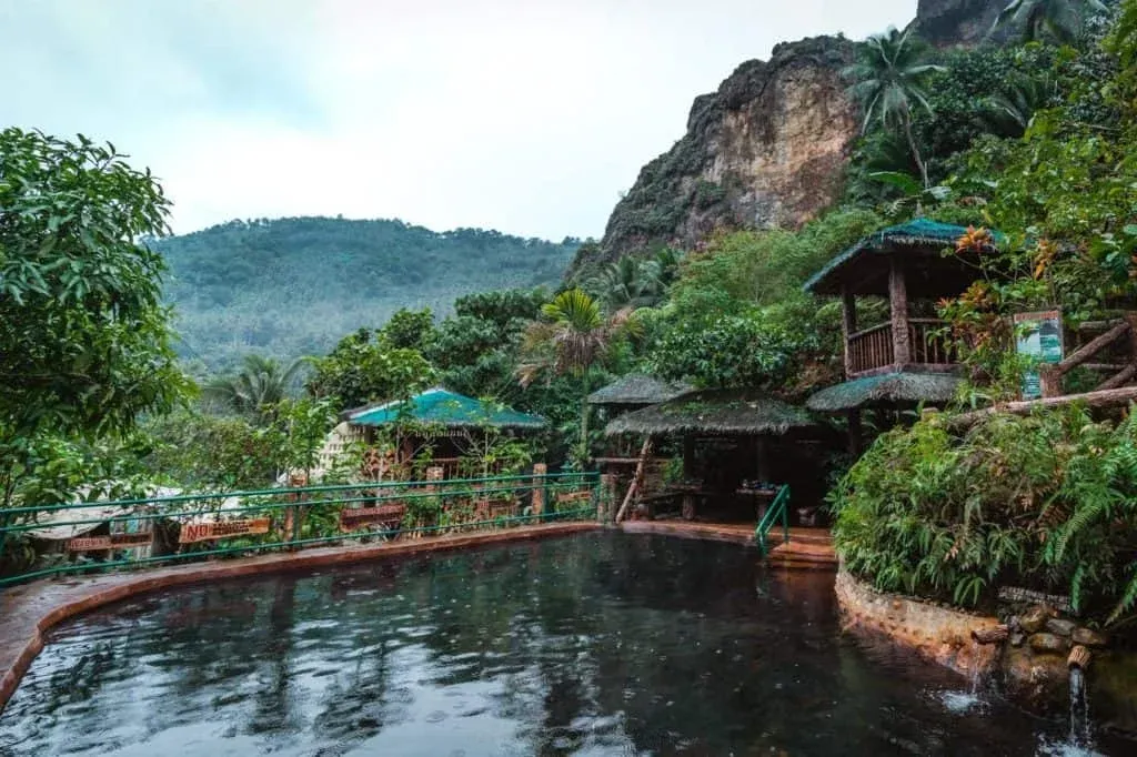Scenic Valencia Pulangbato Falls with red rock cliffs
