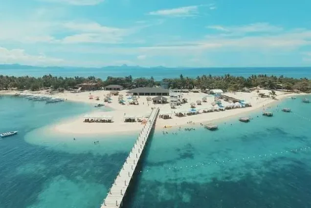 Tourists enjoying the tropical beach scenery at Lakawon Beach Resort in Cadiz, Negros Occidental.