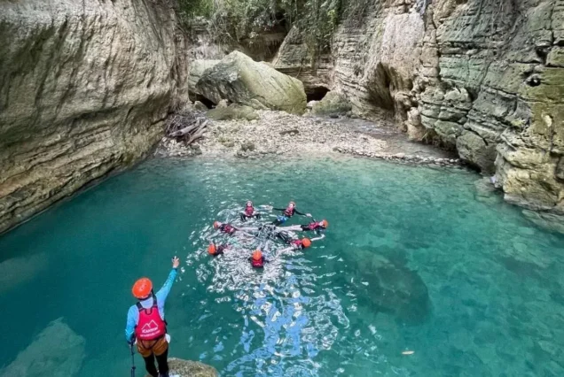 Tourists enjoying canyoneering through turquoise pools and waterfalls in Badian, Cebu.