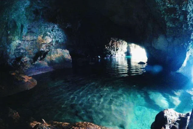 Baras Cave in Guimaras, featuring dramatic rock formations, a natural cave opening, and surrounding coastal scenery.