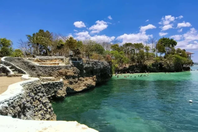 Natago Beach in Guimaras, featuring a secluded tropical shoreline surrounded by lush greenery and clear blue waters.