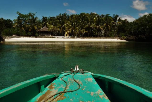 Natago Beach in Guimaras, featuring a secluded tropical shoreline surrounded by lush greenery and clear blue waters.