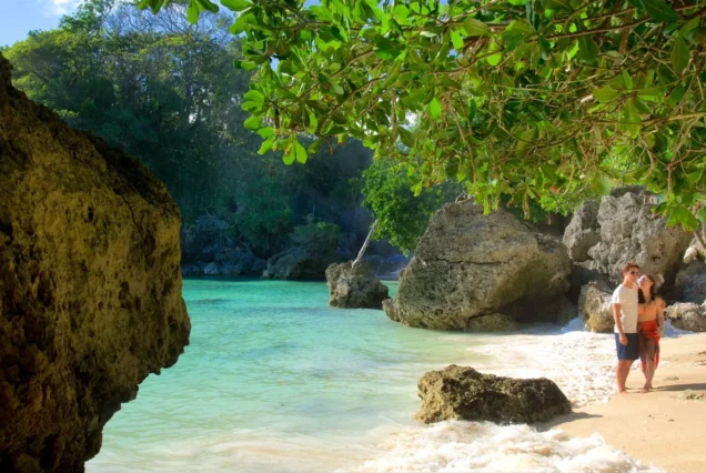 Balinghai Beach in Boracay, Aklan, featuring clear turquoise waters, rocky coastal scenery, and lush tropical greenery.