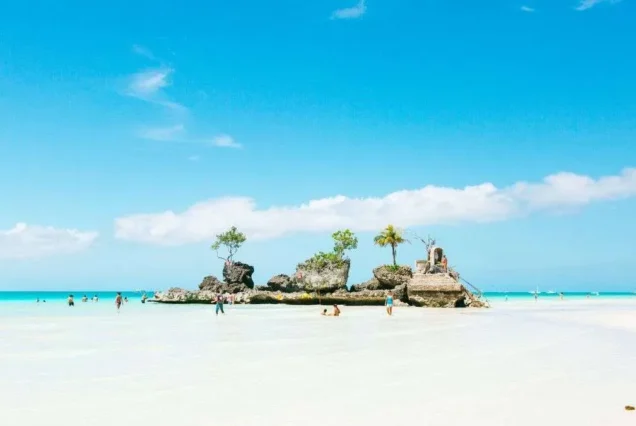 Boracay grotto featuring a small religious shrine set among rocks and lush tropical surroundings near the coast.